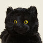 Close-up of a black plush toy with yellow eyes on a beige background