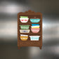 Magnet of a wooden shelf with colorful bowls on a metallic background