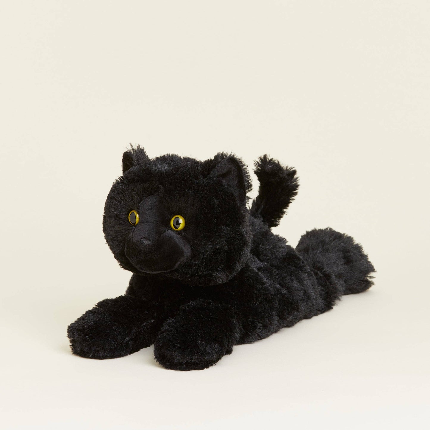 Black plush toy cat on a beige background