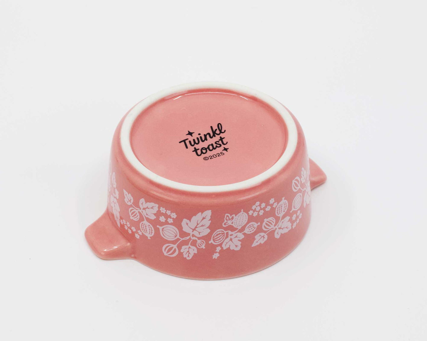 Pink ceramic bowl with floral patterns and 'Twinkl toast' text on a white background
