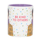 Mug with 'Be Kind to Others' text and colorful confetti pattern on a white background