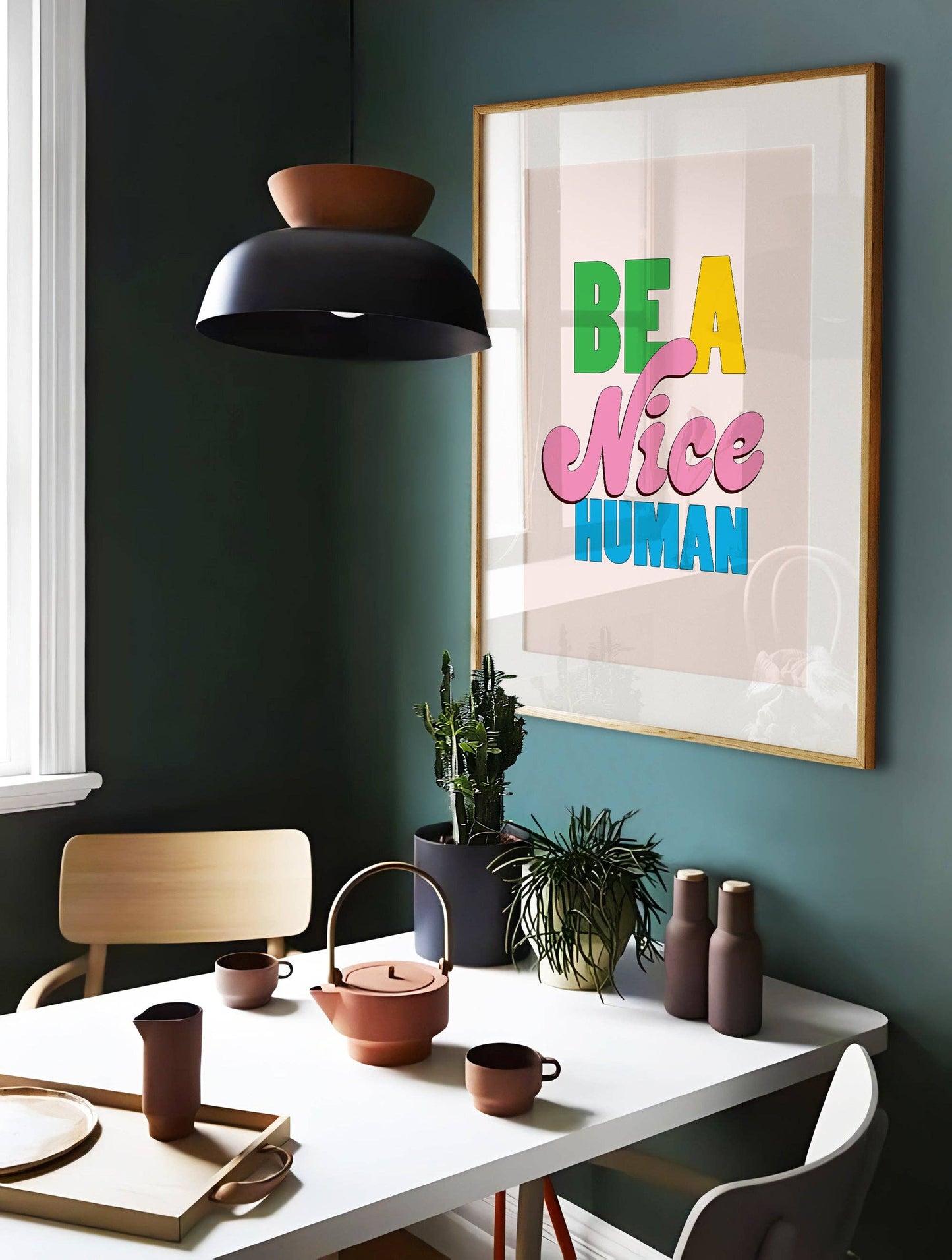 Modern interior with a dining table, chairs, and a motivational poster on the wall.