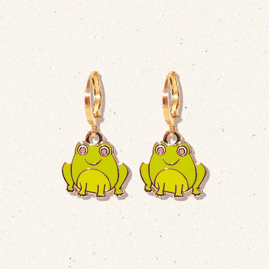 Frog-shaped earrings with gold hooks on a light background