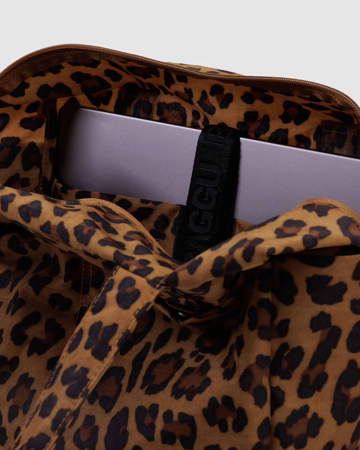 Leopard print bag with a visible brand logo on a light gray background