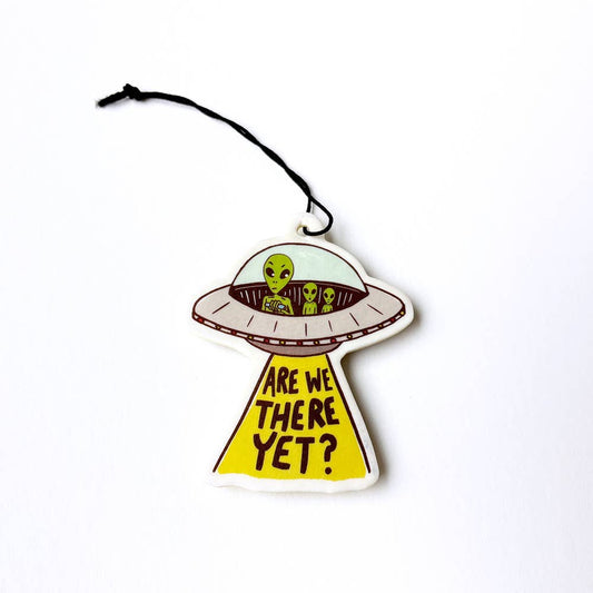 Alien spaceship air freshener with 'Are we there yet?' text on a white background