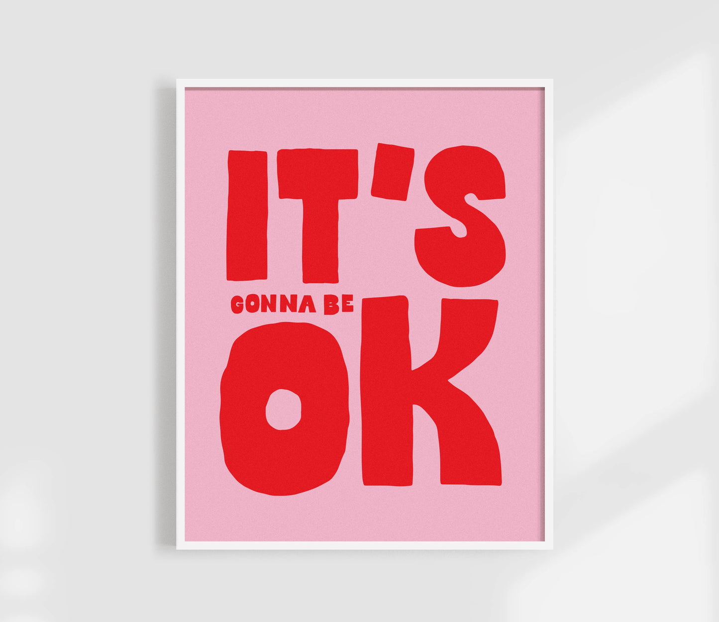 Pink poster with red text 'IT'S GONNA BE OK' on a light gray background