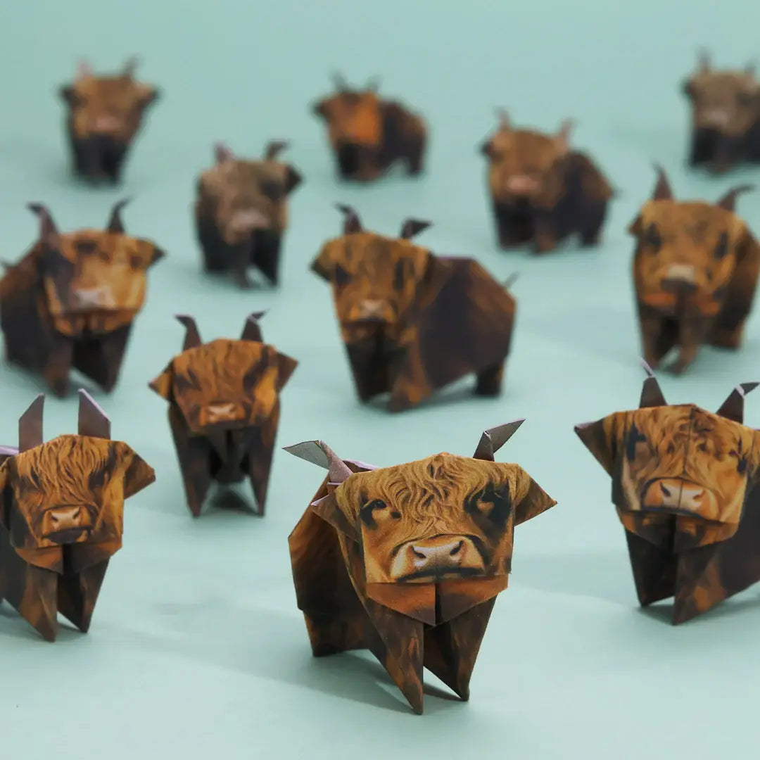 Origami highland cows on a light blue background