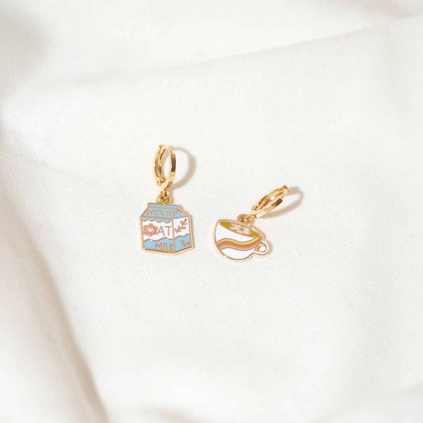 mismatched gold huggie earrings of oat milk and coffee on a white background