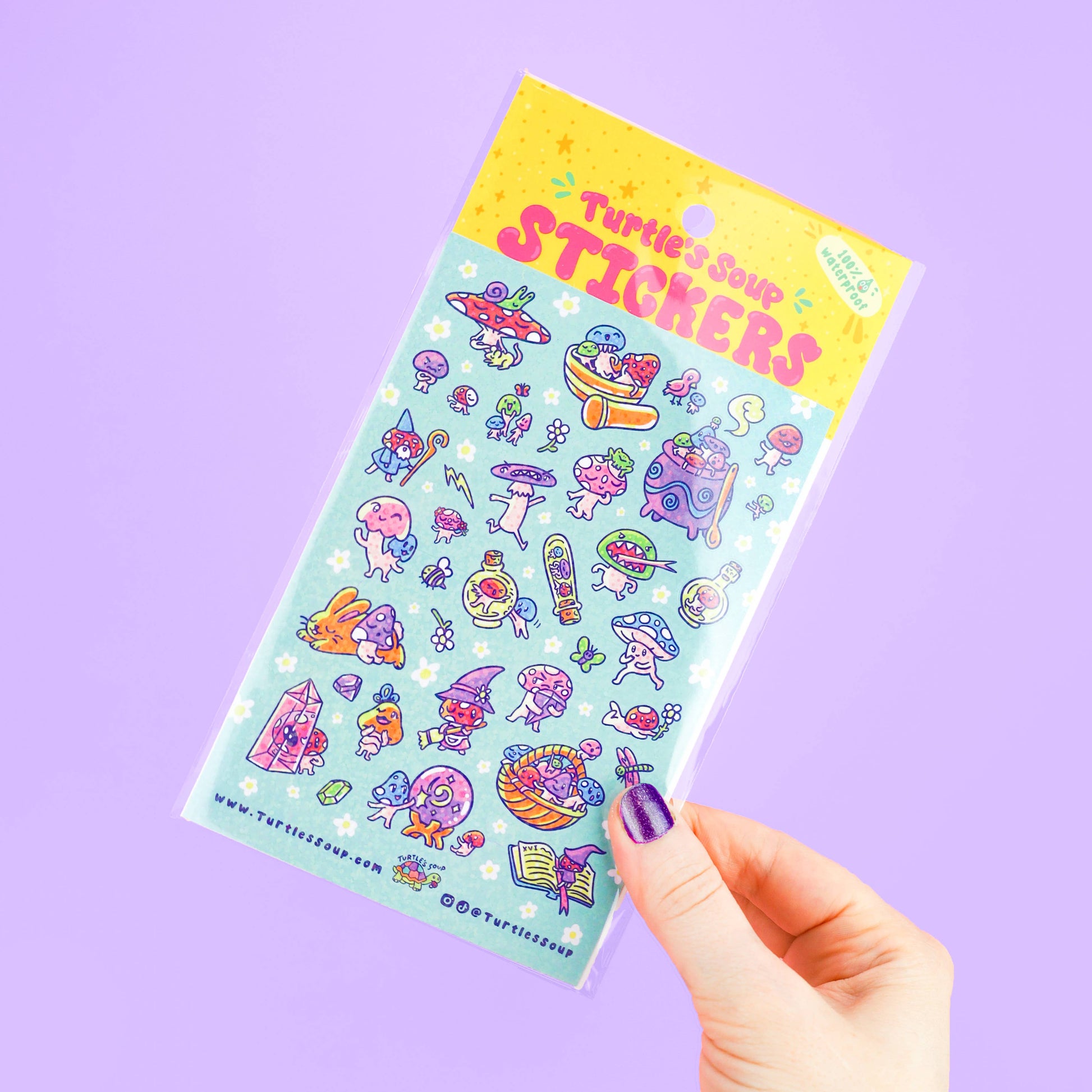 Sheet of colorful stickers held by a hand on a purple background