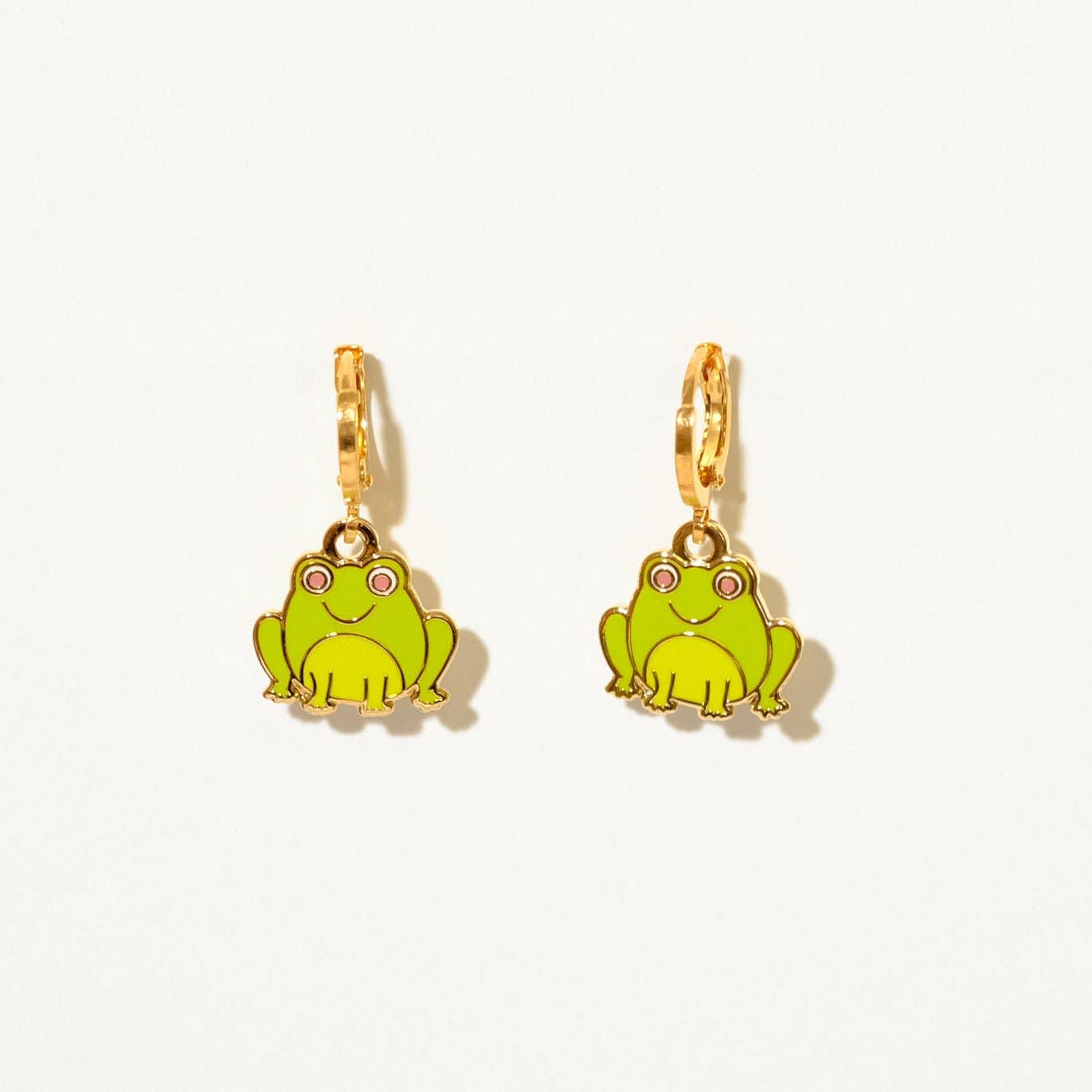 Green frog-shaped earrings with gold hooks on a white background