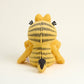 Yellow cat Garfield plush toy with black patterns on a beige background
