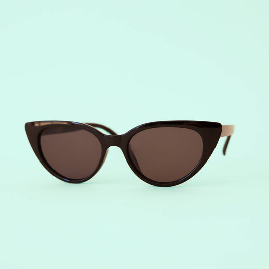 Cat-eye sunglasses with brown lenses on a light green background