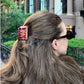 Person with a pride and prejudice book hair clip in an urban setting