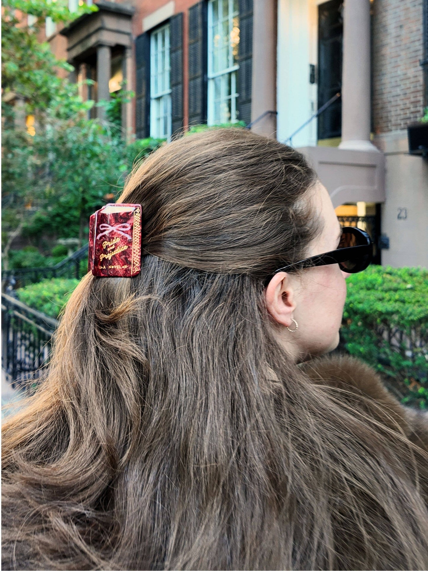 Person with a pride and prejudice book hair clip in an urban setting
