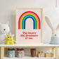 Framed rainbow poster with text on a shelf with toys and decor