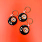 Three billiard ball keychains with number 8 on an orange background