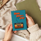 Person holding a Father's Day card with a cassette tape design on a textured surface.