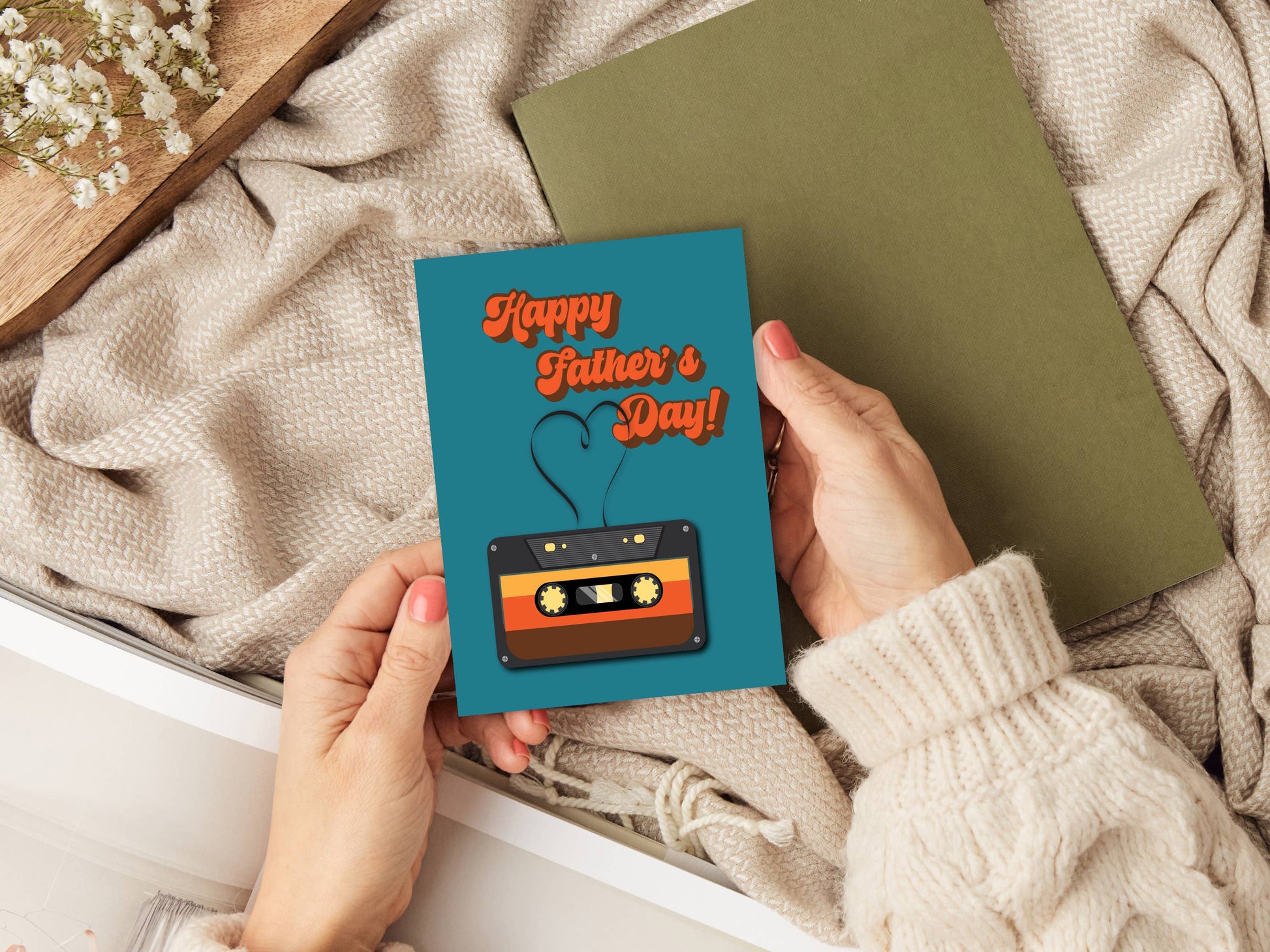 Person holding a Father's Day card with a cassette tape design on a textured surface.