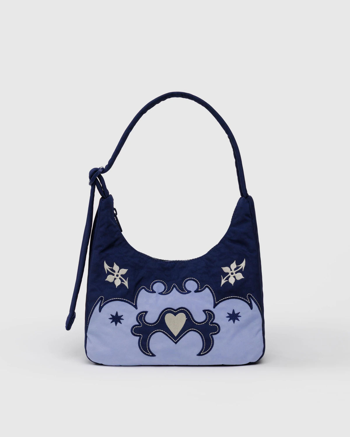 Navy blue handbag with white floral designs on a light gray background