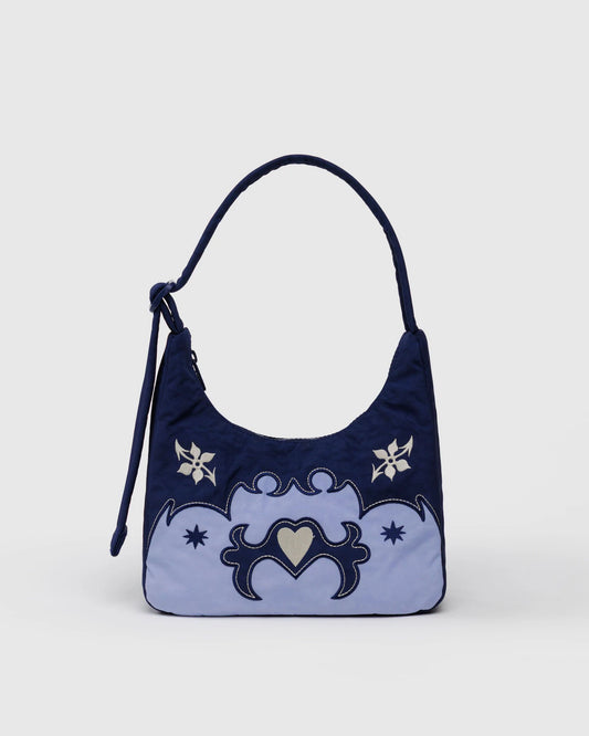 Navy blue handbag with white floral designs on a light gray background