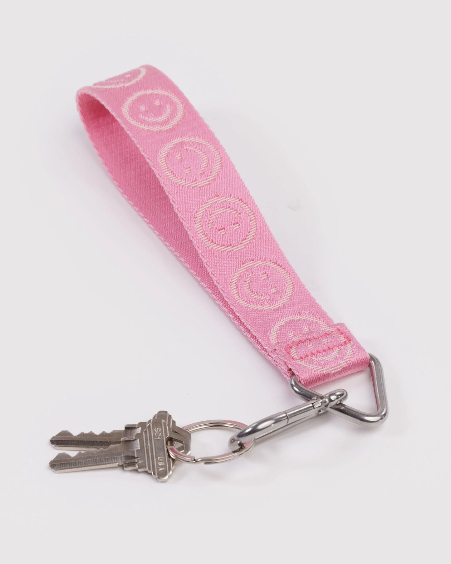Pink keychain with smiley face pattern on a white background