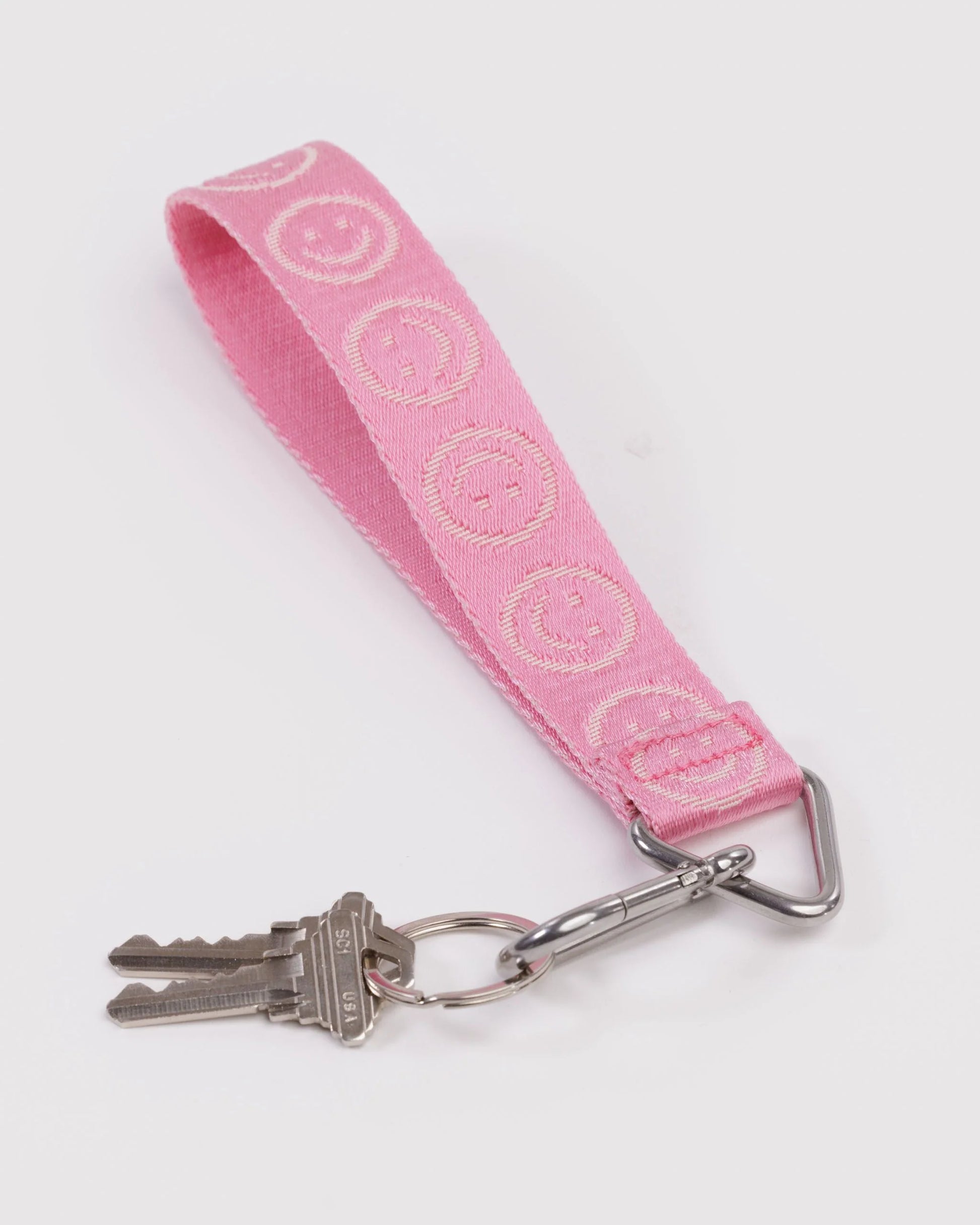Pink keychain with smiley face pattern on a white background