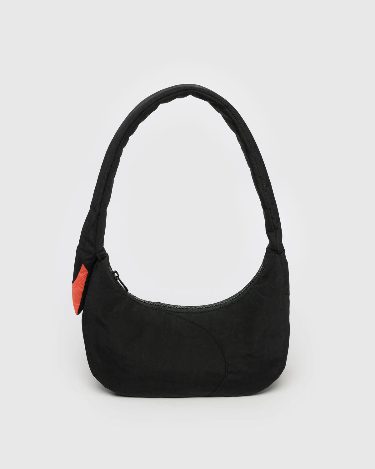 Black shoulder bag with a red tag on a light gray background