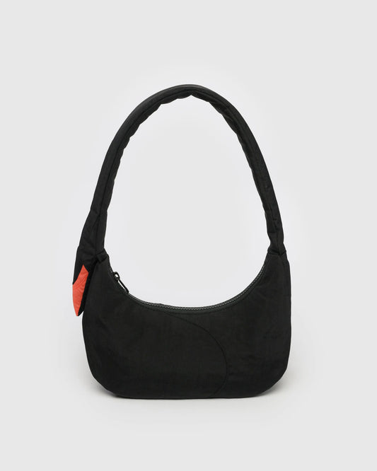 Black shoulder bag with a red tag on a light gray background