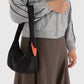 Person holding a black bag with a swan design on a white background