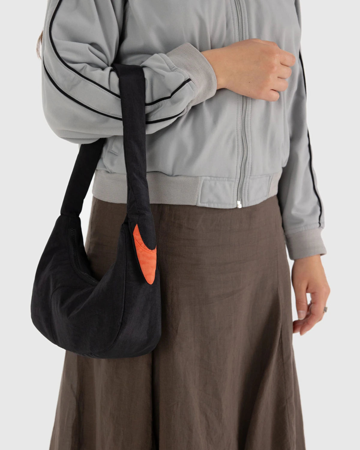 Person holding a black bag with a swan design on a white background