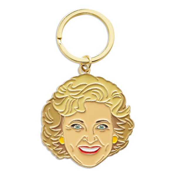 Gold keychain with a face design on a white background