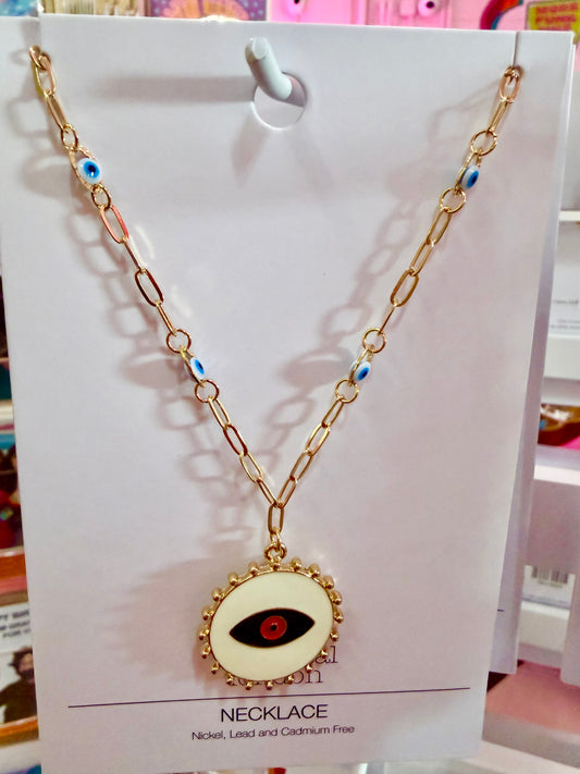 Gold necklace with eye pendant on a white card