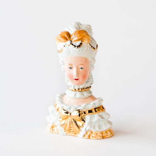 A pair of Marie Antoinette salt and pepper shakers depicting the character in vintage style clothing.