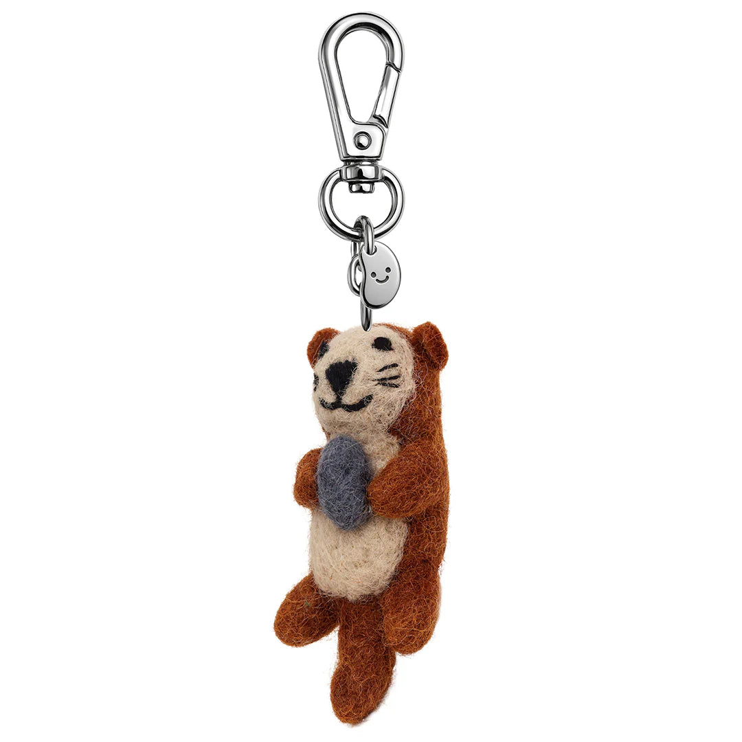 Plush otter keychain with a rock on a white background
