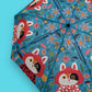 Colorful umbrella with fox and floral design on a blue background
