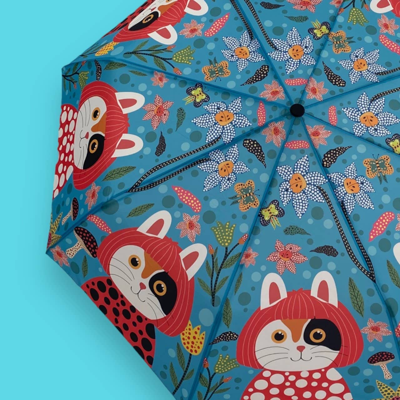 Colorful umbrella with fox and floral design on a blue background