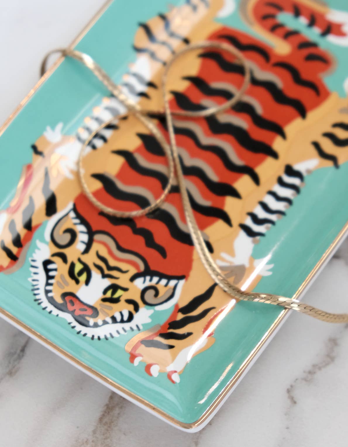 Trinket tray with tiger design on a marble surface