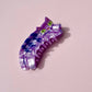 Colorful cat-shaped hair clip on a pink background