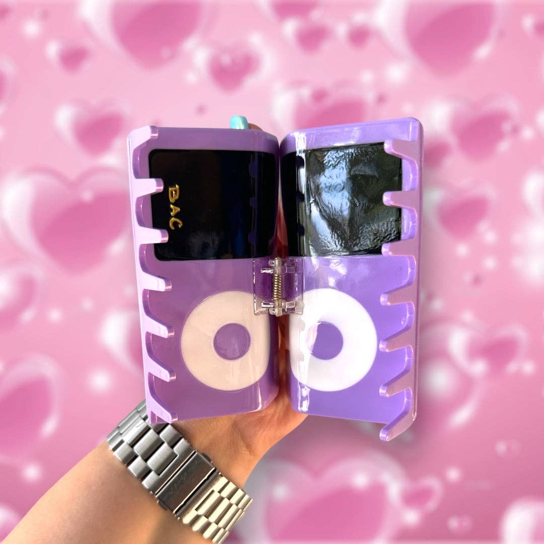 Purple Ipod hair claw held by a hand with a pink heart patterned background