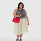 Woman holding a red bag against a white background