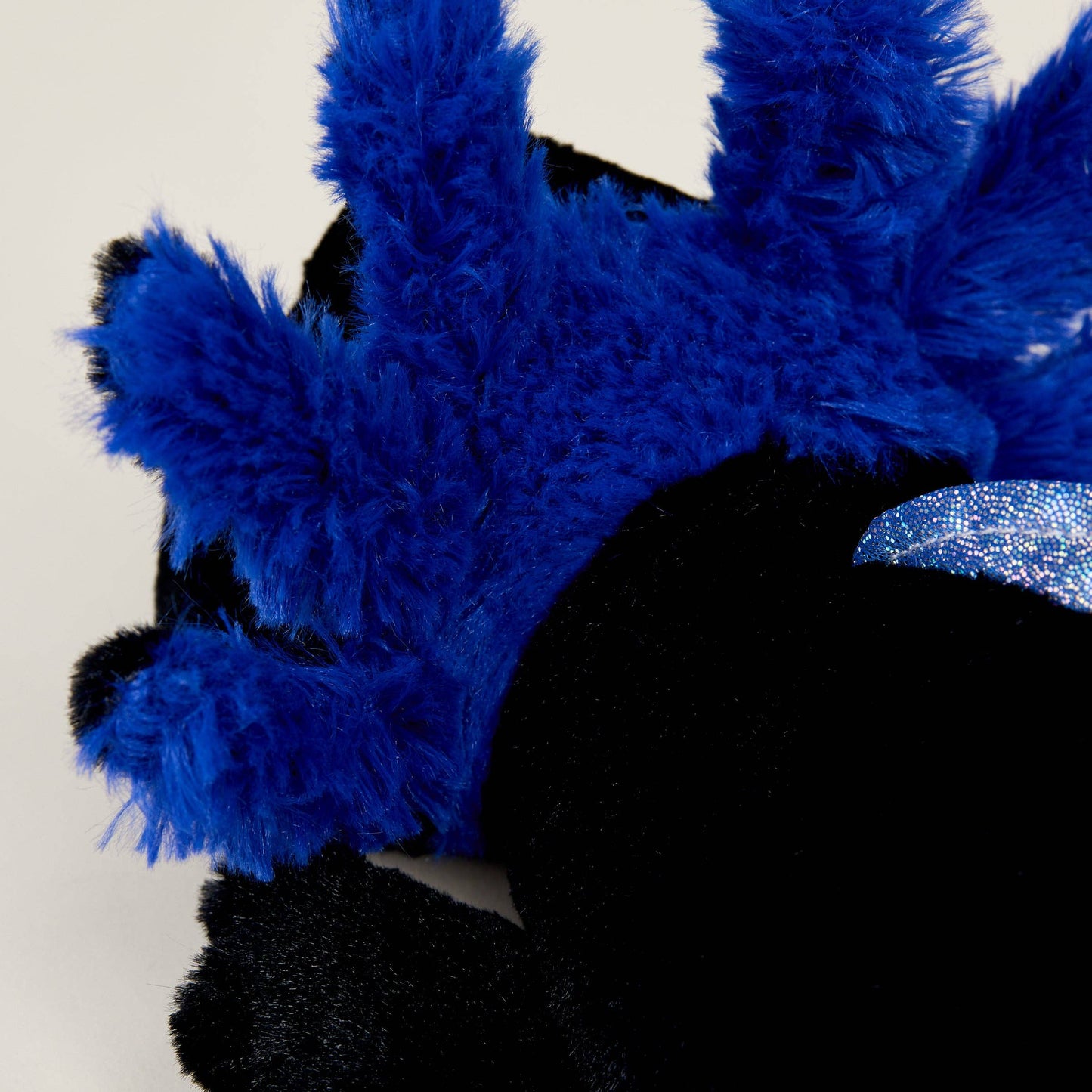 Close-up of a blue and black plush toy with fluffy texture.