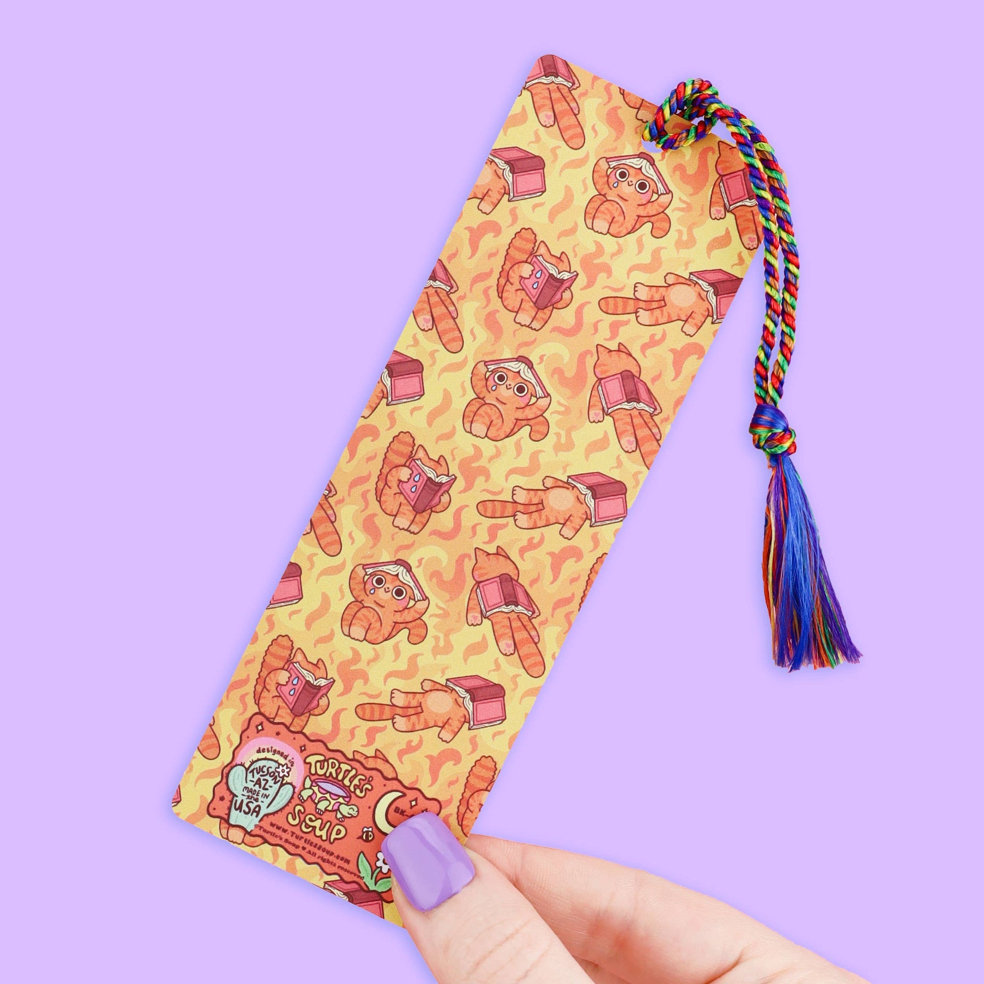 Bookmark with cat character pattern and colorful tassel on a purple background