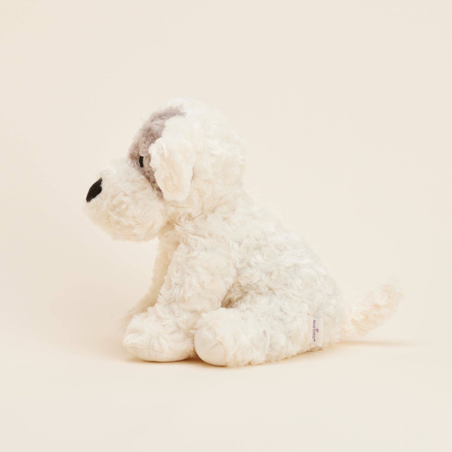 White plush dog toy on a beige background