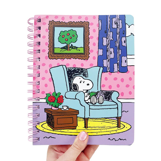 Notebook with a snoopy sitting on a couch in a living room.