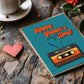 Father's Day card with cassette tape design on a wooden surface with hearts and a cup.