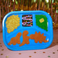 Children's blue tray with dinosaur-shaped compartments on a festive background