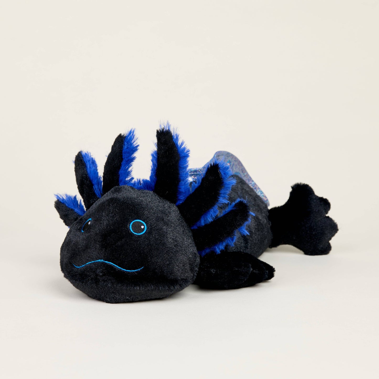 Black and blue axolotl stuffed animal on a light gray background
