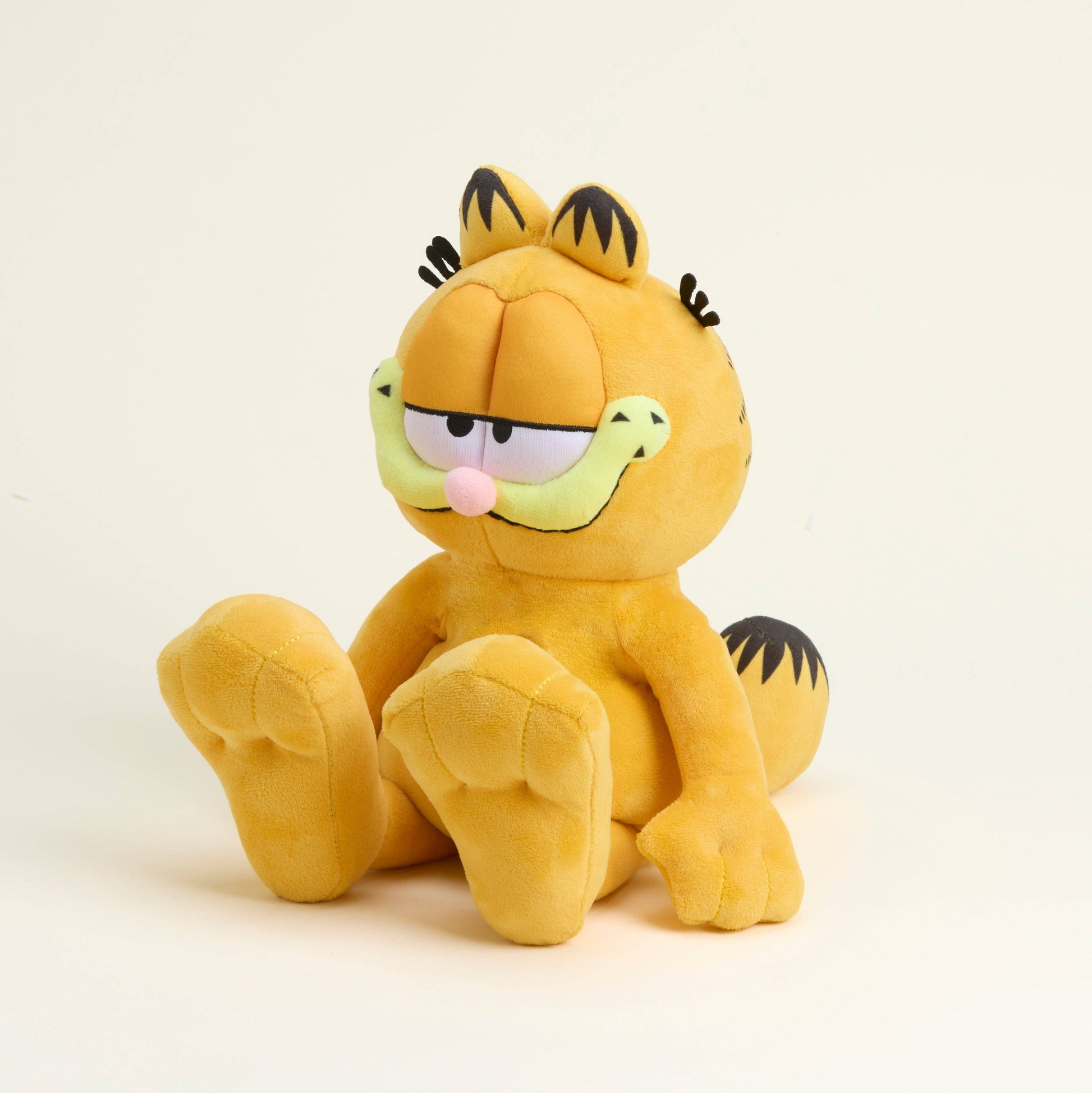 Plush toy of a cartoon cat character Garfield on a beige background