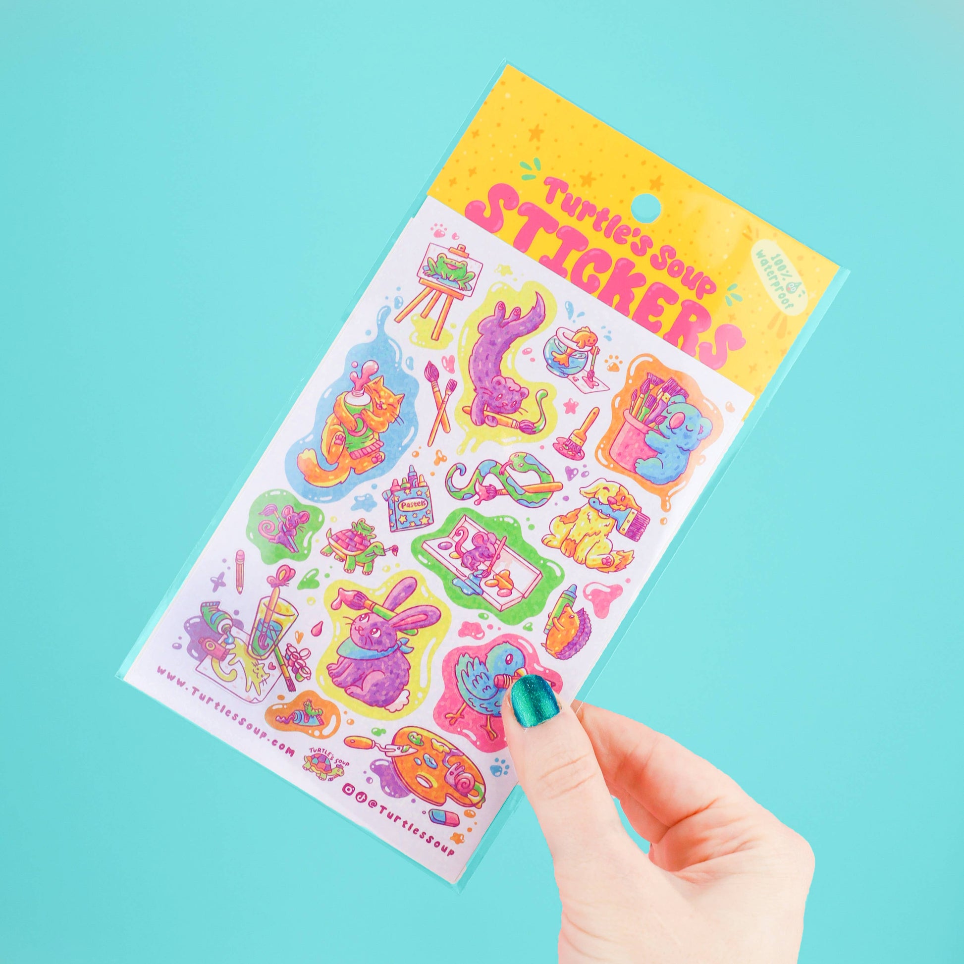 Sheet of colorful stickers held by a hand against a light blue background