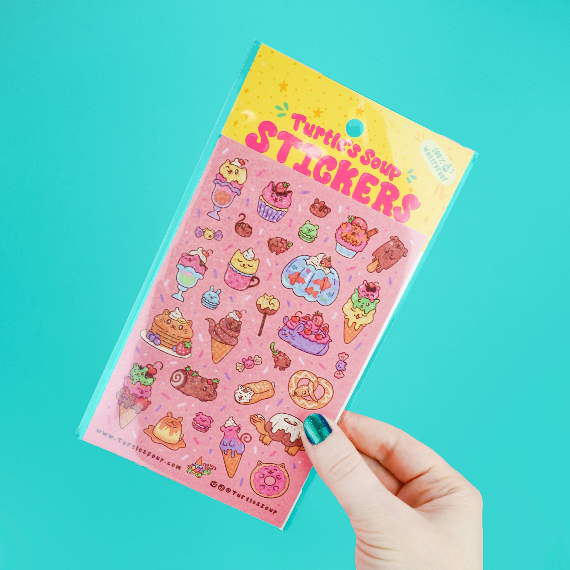 Sheet of colorful stickers held by a hand against a teal background